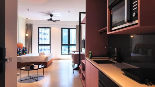 a room with a kitchen and a bedroom with a bed at Paxtonz Suite Kuala Lumpur in Petaling Jaya