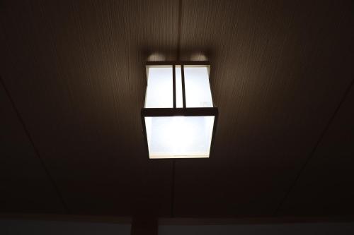 a light hanging from a wall in a dark room at sakurayuki in Otaru