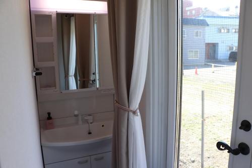 a bathroom with a sink and a mirror and a window at sakurayuki in Otaru