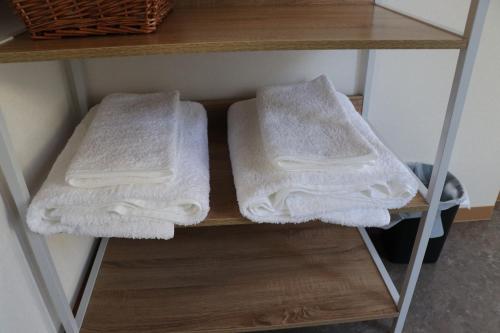 two white towels are sitting on a shelf at sakurayuki in Otaru