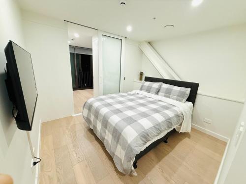 a bedroom with a bed and a flat screen tv at Modern City Living with the Harbour Views in Wellington
