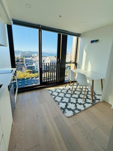 a living room with a white desk and large windows at Modern City Living with the Harbour Views in Wellington