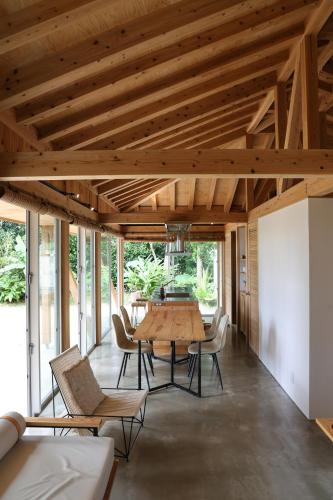 a dining room with a wooden table and chairs at 久米島 SHINMINKA Villa in Kumejima