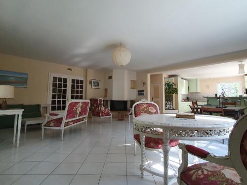 - un salon avec des chaises et une table dans l'établissement Spacieuse Maison 10 Pers Animaux Permis Proche Plage et Forêt - FR-1-476-231, à LʼAiguillon-sur-Mer