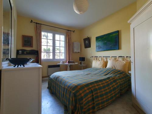 une chambre avec un lit et un chat assis sur un comptoir dans l'établissement Spacieuse Maison 10 Pers Animaux Permis Proche Plage et Forêt - FR-1-476-231, à LʼAiguillon-sur-Mer