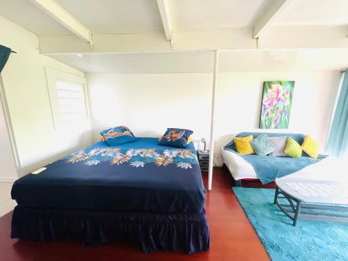 a bedroom with a bed and a couch at La Cabane de Hotu in Papeete