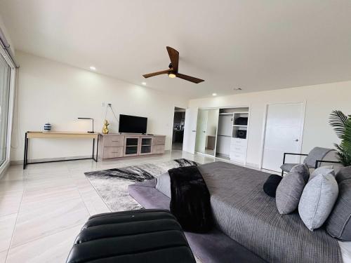 Un dormitorio con una cama y un ventilador de techo. en Beachfront Apartment with 3 BR 2 BA with pool, en Rosarito