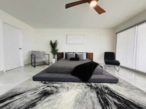 Un dormitorio con una cama grande y un ventilador de techo. en Beachfront Apartment with 3 BR 2 BA with pool, en Rosarito