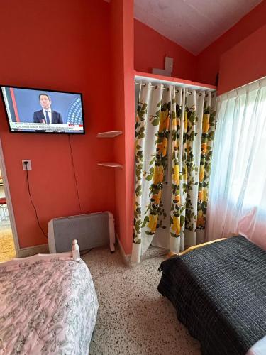 a bedroom with a bed and a tv on a wall at La Clementina in San Clemente del Tuyú