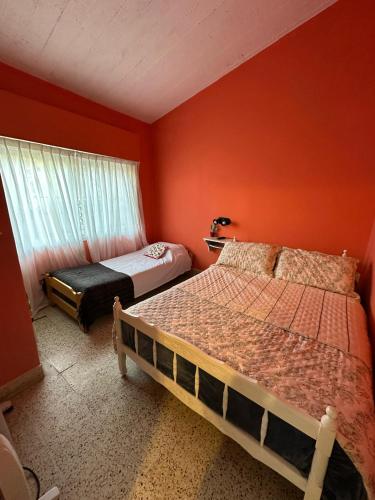圣克莱门特雷图尤La Clementina的橙色墙壁的房间里有两张床