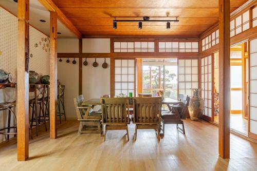 Un comedor con mesa y sillas en 潮宿enjoykeys A private rental space with a Japanese garden, en Higashiōsaka