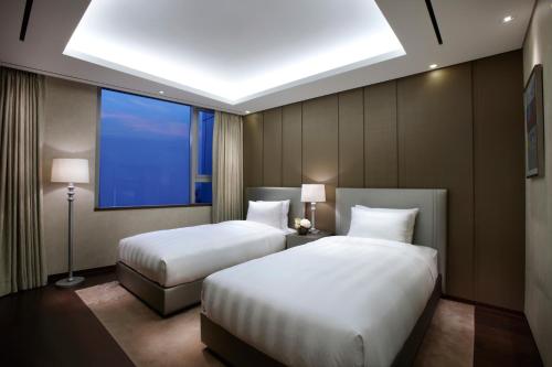 a hotel room with two beds and a window at LOTTE City Hotel Guro in Seoul