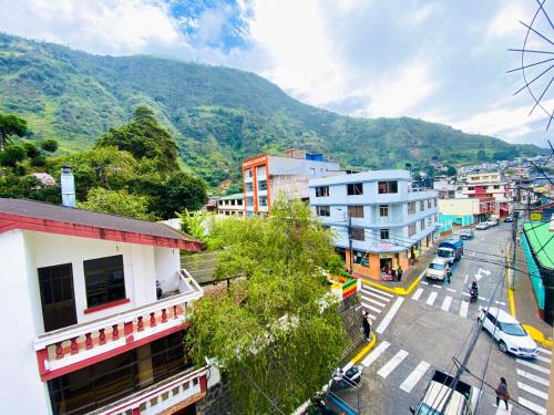 Blick auf eine Stadt mit einem Berg im Hintergrund in der Unterkunft Hostal Green Garden in Baños