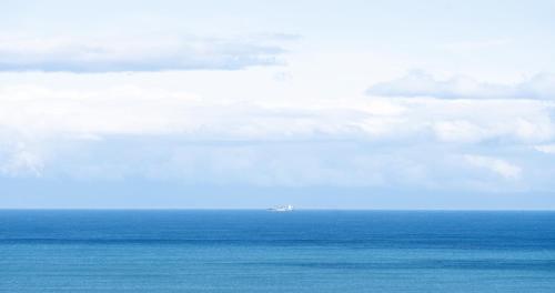 an airplane is flying over the ocean at Hotel SEASONS NICHINAN in Nichinan