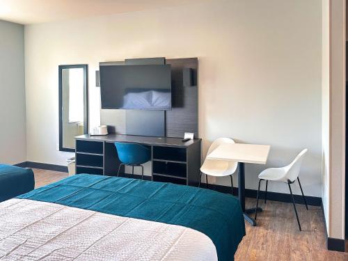 a hotel room with a bed and a desk at Studio 6 Richmond-Airport in Sandston