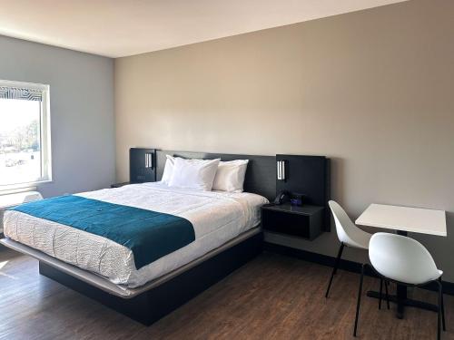a bedroom with a bed and a table and a chair at Studio 6 Richmond-Airport in Sandston