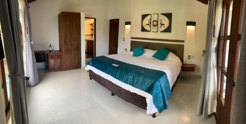 a bedroom with a large bed and a bathroom at hotel torres del viento in Villa de Leyva