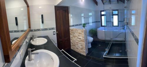 a bathroom with two sinks and a tub and a toilet at hotel torres del viento in Villa de Leyva
