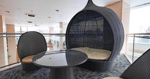 a room with a table and chairs on a balcony at Hotel SEASONS NICHINAN in Nichinan