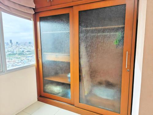 a wooden cabinet with a window in a room at Strategic 2BR Thamrin Apt with Pool & Gym by 2ndHome in Jakarta