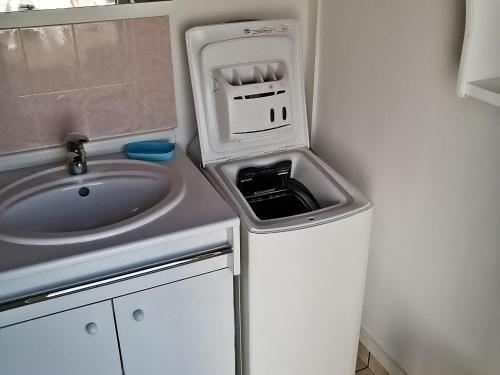 une petite salle de bains avec un lavabo et un sinkiterator dans l'établissement Maison proche plage, 3 pers, animaux admis - FR-1-823-128, à Noirmoutier-en-l'lle