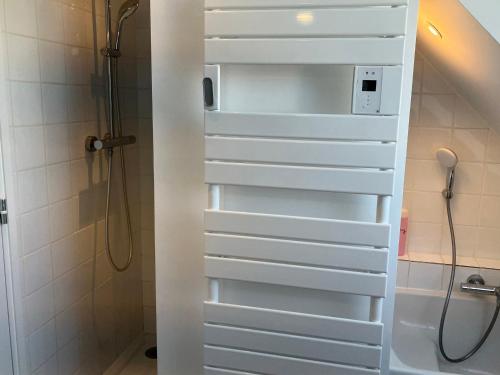 La salle de bains est pourvue d'une douche et d'une porte blanche. dans l'établissement Villa contemporaine spacieuse proche de Sauzon avec jardin - FR-1-418-265, à Sauzon