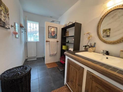 La salle de bains est pourvue d'un grand miroir et d'un lavabo. dans l'établissement Grande maison basque avec terrasse et parking à Ciboure - FR-1-239-1113, à Ciboure