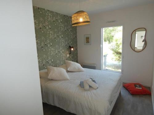 une chambre avec un lit avec un animal en peluche dessus dans l'établissement Maison moderne et calme à Notre-Dame-de-Monts, 8 personnes - FR-1-540-321, à Notre-Dame-de-Monts