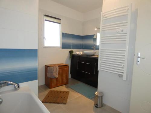 une salle de bain avec un lavabo et une baignoire dans l'établissement Maison moderne et calme à Notre-Dame-de-Monts, 8 personnes - FR-1-540-321, à Notre-Dame-de-Monts