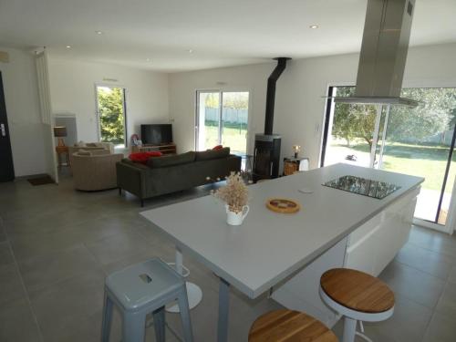 une cuisine et un salon avec un comptoir blanc dans l'établissement Maison moderne et calme à Notre-Dame-de-Monts, 8 personnes - FR-1-540-321, à Notre-Dame-de-Monts