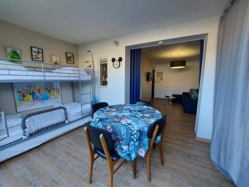 Cette chambre comprend une table et deux lits superposés. dans l'établissement Studio rénové Argelès-sur-Mer proche plages avec piscine - FR-1-776-134, à Argelès-sur-Mer