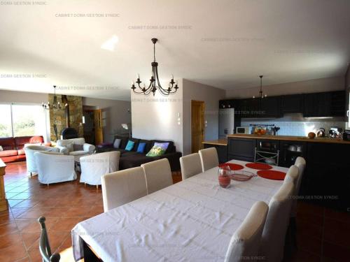 une cuisine et un salon avec une table et des chaises blanches dans l'établissement Villa luxueuse à Sampzon avec piscine et climatisation - FR-1-697-36, à Sampzon