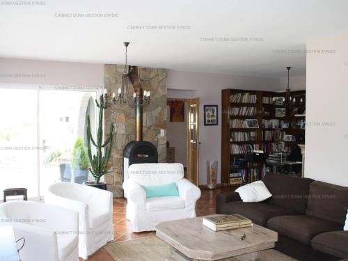 Elle comprend un salon doté d'un mobilier blanc et d'une cheminée. dans l'établissement Villa luxueuse à Sampzon avec piscine et climatisation - FR-1-697-36, à Sampzon