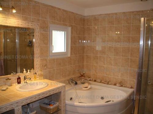 une salle de bain avec une baignoire et un lavabo dans l'établissement Villa luxueuse à Sampzon avec piscine et climatisation - FR-1-697-36, à Sampzon