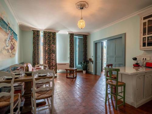 une cuisine et une salle à manger avec une table et des chaises dans l'établissement Appartement historique, animaux admis, centre de Pézenas - FR-1-607-213, à Pézenas