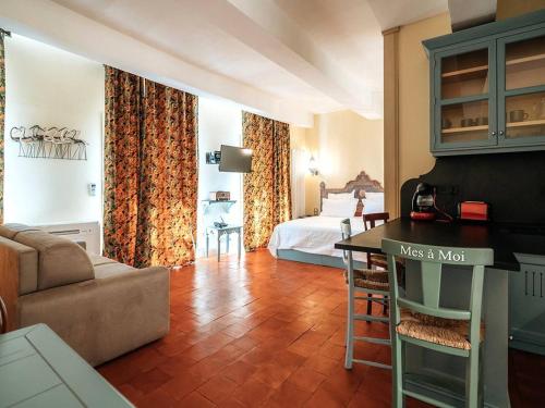 - un salon avec un canapé et un lit dans une chambre dans l'établissement Appartement de charme climatisé, centre historique de Pézenas - FR-1-607-214, à Pézenas