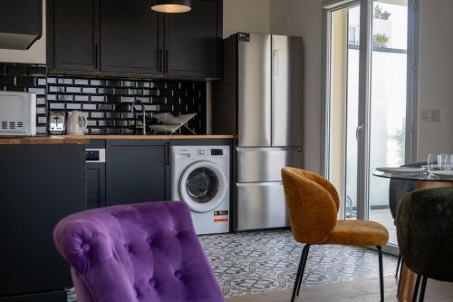Il comprend une cuisine équipée d'un fauteuil violet et d'un réfrigérateur. dans l'établissement GuestReady - Nature Escape in Nice, à Nice
