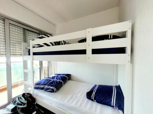 - un lit superposé avec des oreillers bleus dans une chambre dans l'établissement Beau studio cabine avec parking et climatisation, idéal pour 4 personnes - FR-1-794-161, à Canet