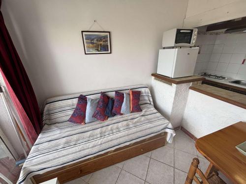 Cette chambre comprend un lit avec 4 oreillers. dans l'établissement Appartement cosy 2 pièces en bord de mer - FR-1-229C-110, à Port-la-Nouvelle