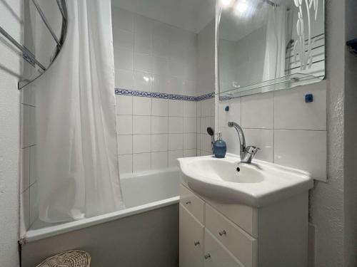 une salle de bain blanche avec un lavabo et une douche dans l'établissement Studio cabine 4 pers. à Gruissan avec parking et clim - FR-1-229-895, à Gruissan