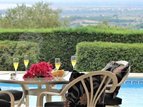 a table with glasses of wine and flowers on it at Alquiler de espaciosa casa en privilegiada zona residencial cercana a Roses y Empuriabrava - ES-366-9 in Palau-Saverdera