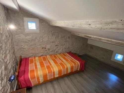 a small room with a bed in a attic at Chaleureuse maisonnette au cœur de Ruoms avec terrasse et parking - FR-1-697-35 in Ruoms