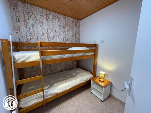 Cette petite chambre comprend 2 lits superposés et une table. dans l'établissement Gîte familial à Talmont-Saint-Hilaire avec cour privée - FR-1-426-579, à Saint-Hilaire-de-Talmont