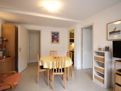 une cuisine et une salle à manger avec une table et des chaises dans l'établissement Mont-Dore T2 avec balcon et parking proche centre - FR-1-415-158, à Mont-Dore