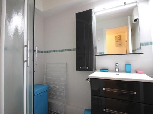 une salle de bain avec un lavabo et un miroir dans l'établissement Mont-Dore T2 avec balcon et parking proche centre - FR-1-415-158, à Mont-Dore