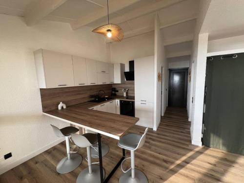 une cuisine avec une table et des tabourets dans une pièce dans l'établissement Villa T3 rénovée, 4 pers, face mer, clim, WiFi, Port Leucate - FR-1-81-633, à Port-Leucate