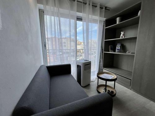 un salon avec un canapé et une grande fenêtre dans l'établissement Studio cabine - 4 pers - Près de la plage - Cap d'Agde - FR-1-249-428, au Cap d'Agde