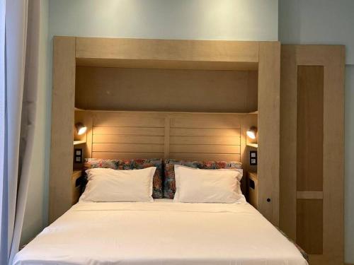 a large bed with white sheets and pillows at Studio de charme climatisé centre de Pézenas, animaux admis - FR-1-607-212 in Pézenas