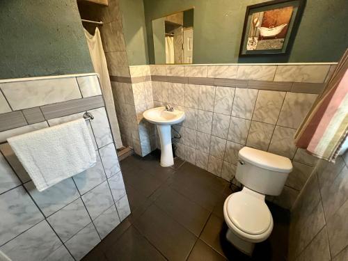 a bathroom with a toilet and a sink at Super Inn motel By Downtown Pomona in Pomona