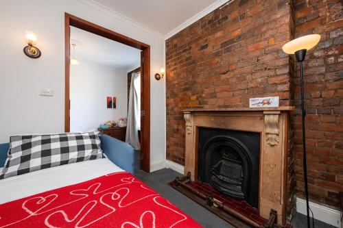 a room with a brick wall and a fireplace at Saint Francis in Fitzroy in Melbourne